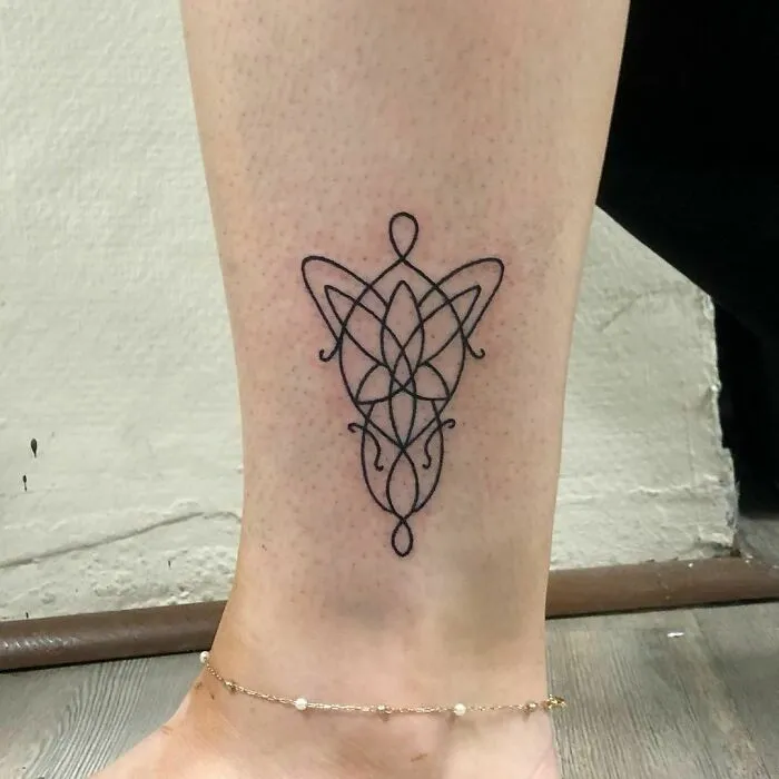 Elvish Lord of the Rings tattoo on a person's ankle, featuring intricate linework.