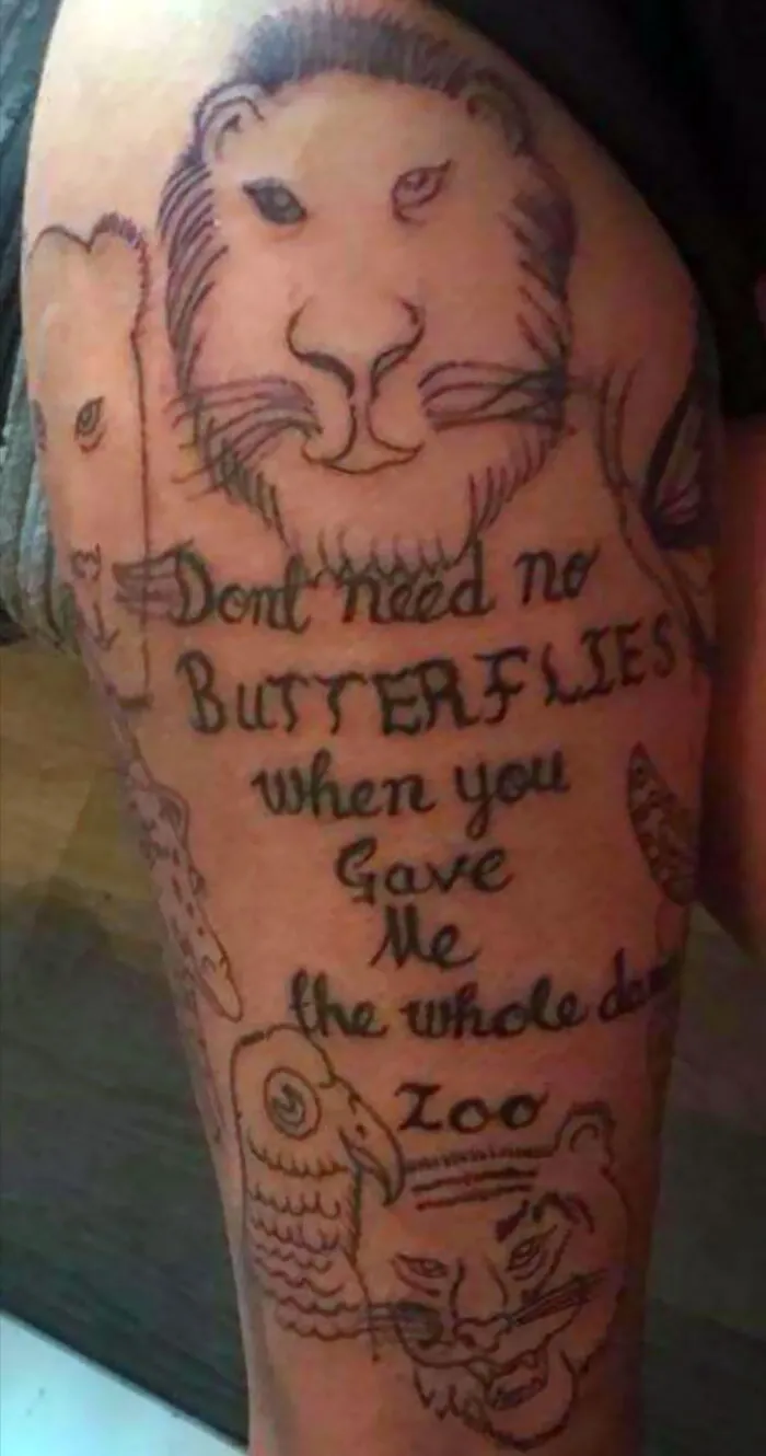 Tattoo of a lion and tiger with text, showcasing permanent inked mistakes.