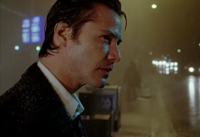 Keanu Reeves wearing suit in the rain