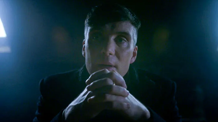 Tommy Shelby folding his hands in front of him