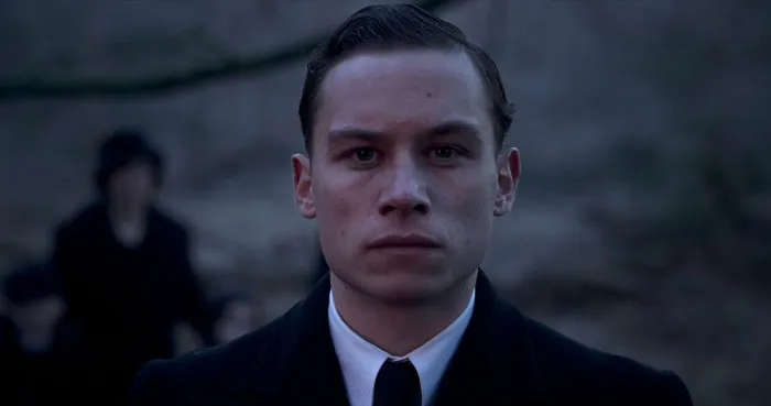 Michael Shelby standing and looking straight with no expression