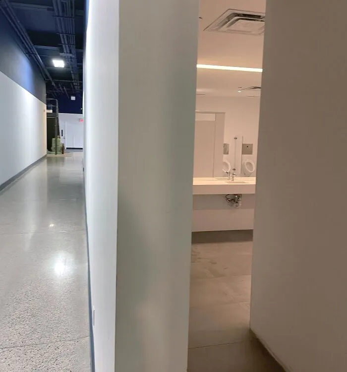 The Positioning Of The Mirror And Urinals In Our Office Building. This Is The Main Hallway