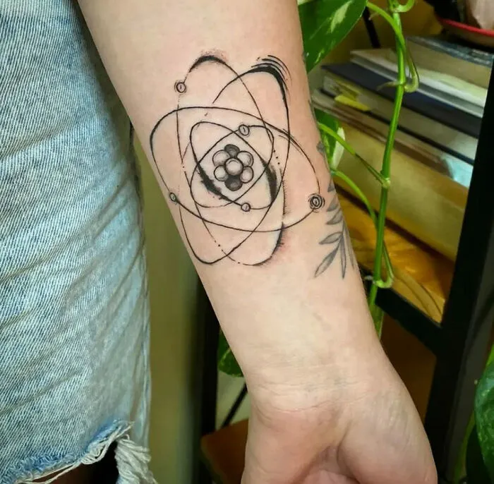 Science tattoo of an atomic design on a person's forearm, showcasing scientific inspiration and creativity.
