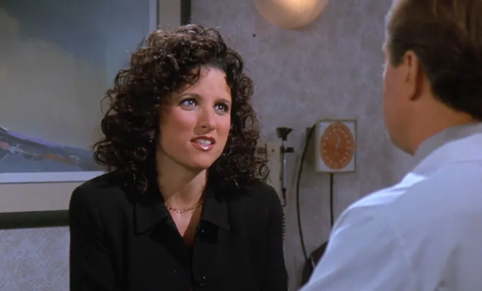 Elaine in a black suit from Seinfeld sharing one of the funniest Seinfeld quotes that sum up everyday life moments.