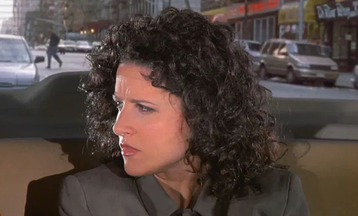 Elaine from Seinfeld looking angry in a gray jacket, capturing one of the funniest Seinfeld quotes moments.