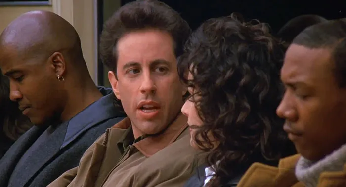 Jerry from Seinfeld wearing a brown jacket, captured in a scene reflecting funniest Seinfeld quotes about everyday life.