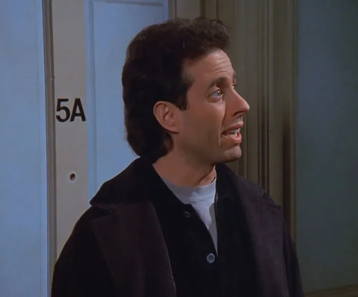 Jerry from Seinfeld wearing a brown jacket and black shirt, captured in a scene reflecting funniest Seinfeld quotes everyday life.
