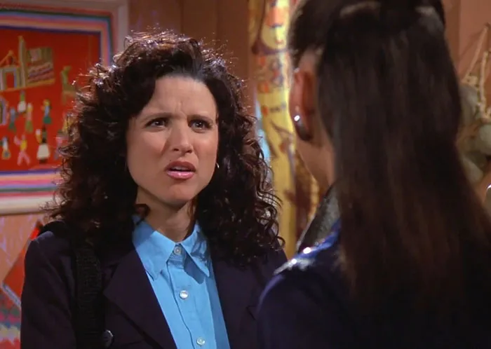 Elaine wearing a black jacket and blue shirt in a Seinfeld scene illustrating funniest Seinfeld quotes about everyday life.