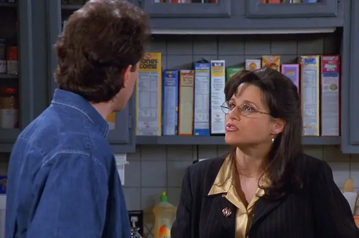Elaine from Seinfeld wearing a black jacket and yellow shirt, showcasing funniest Seinfeld quotes about everyday life.