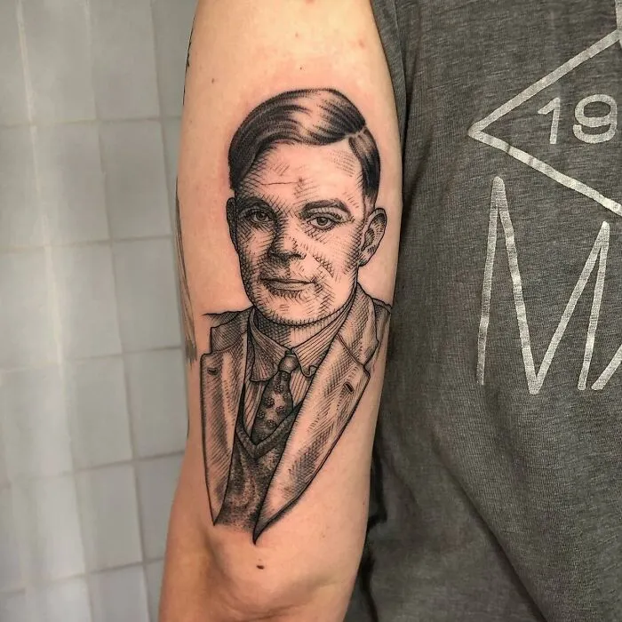 Tattoo of a portrait on an arm, depicting a scientist in a suit and tie, highlighting science tattoos.