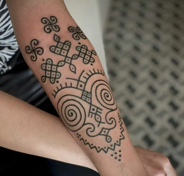Tribal tattoo design on a forearm featuring intricate patterns and spirals.