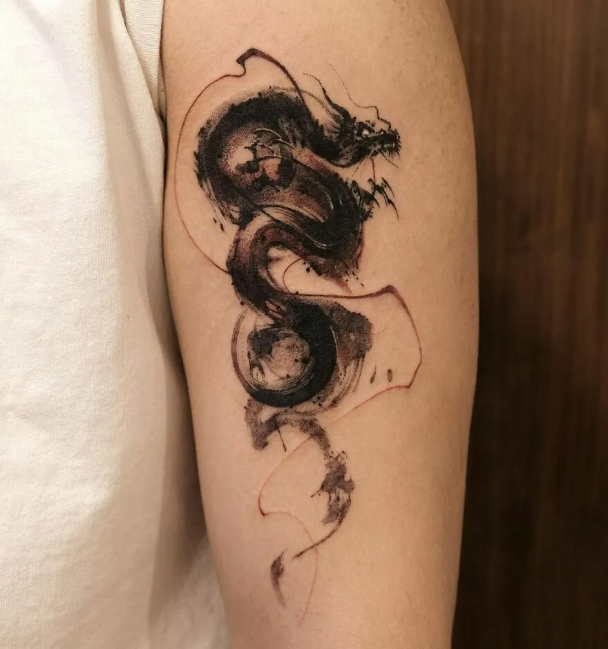 Abstract ink-style dragon tattoo design on upper arm.