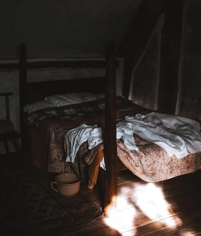 Dark Bedroom And Messy Bed 