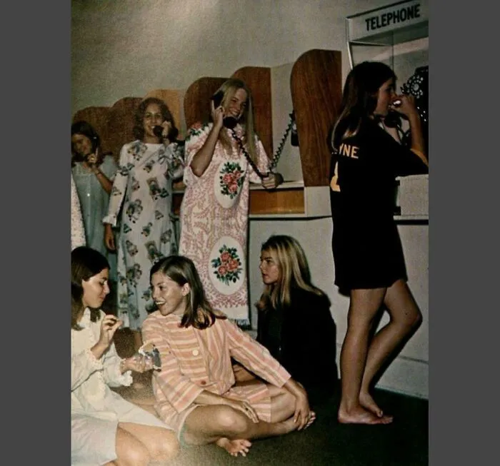 Estudiantes en un colegio mayor femenino haciendo cola para poder llamar a amigos y familia