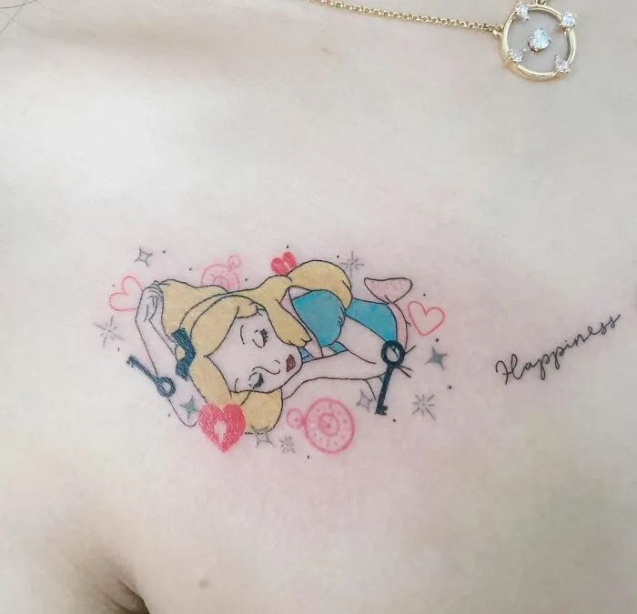 Cartoon tattoo of a blonde character in a blue outfit, surrounded by hearts and sparkles, with the word "Happiness" nearby.