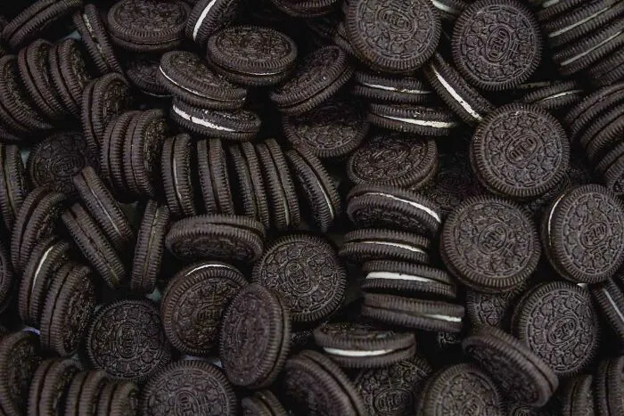 Close-up of many Oreo cookies stacked and scattered, perfect for sharing useless facts to possibly impress your friends.