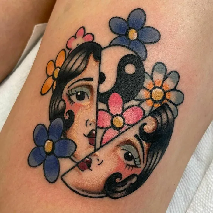 Colorful Yin Yang tattoo featuring woman’s face and flowers.