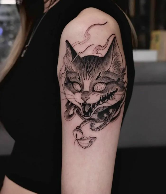 Gothic tattoo of a snarling cat with smoke details on a person's arm.