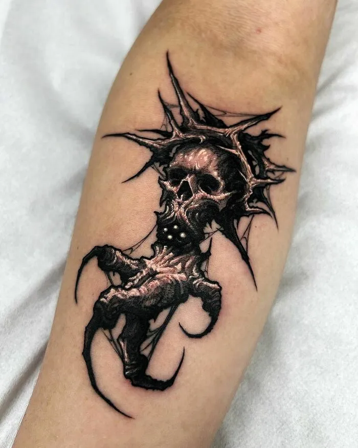 Gothic tattoo featuring a detailed skull with cracked textures and sharp edges on a forearm.