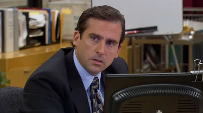 Michael Scott talking seriously at his office desk, illustrating quotes about the best boss ever from the show.