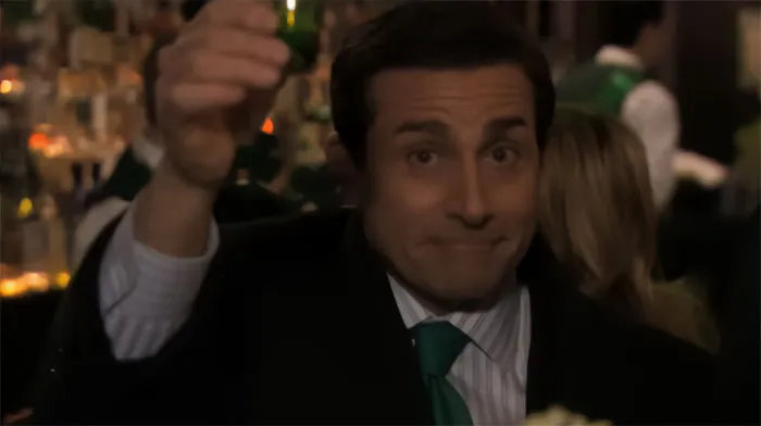 Michael Scott in a suit raising his glass in a bar, exemplifying iconic Michael Scott quotes about being the best boss ever.