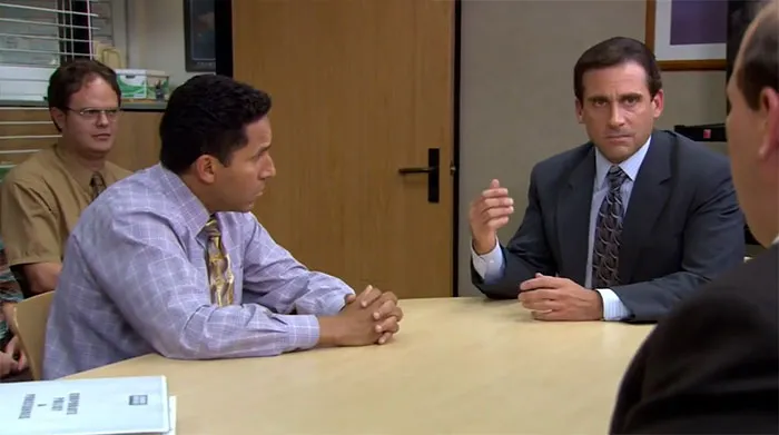 Michael Scott talking in the conference room during a meeting, highlighting iconic Michael Scott quotes about leadership.