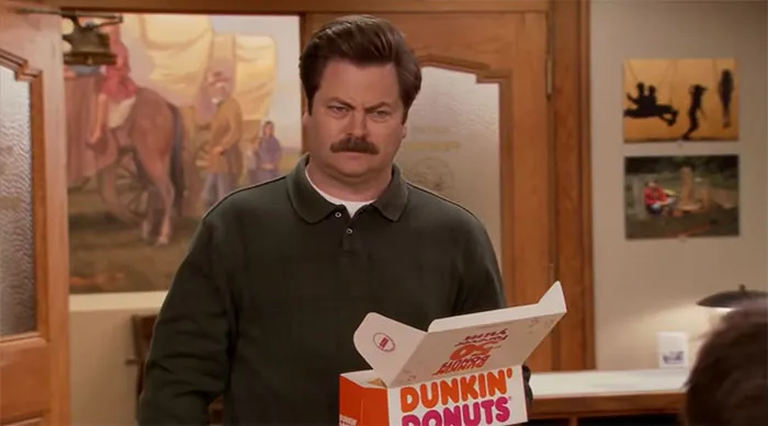 Ron Swanson holding a box of Dunkin Donuts, captured in a scene highlighting famous Ron Swanson quotes.