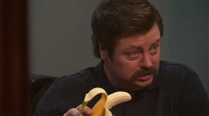 Ron Swanson showing a disgusted reaction while holding a peeled banana, capturing a memorable Ron Swanson quotes moment.