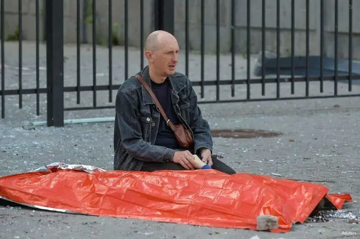 A Father Holding The Hand Of His Deceased 13-Year Old Son Who Was Killed Today Whilst Waiting For A Bus By A Russian Missile Attack In Kharkiv