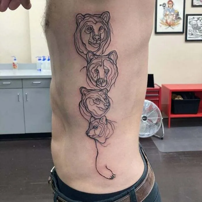 Four animal faces tattooed on side rib symbolize family bonds.