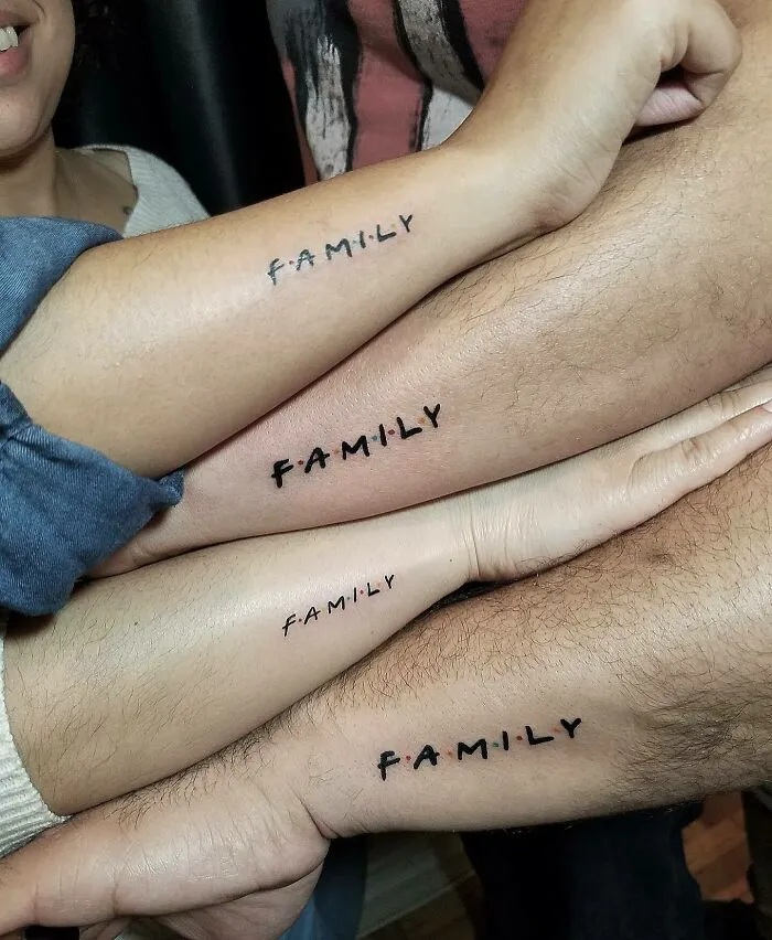 Several arms with matching "Family" tattoos symbolizing unbreakable bonds.