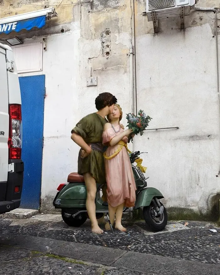 An image of a boy and a girl from “Daphnis And Chloe” painting on a scooter