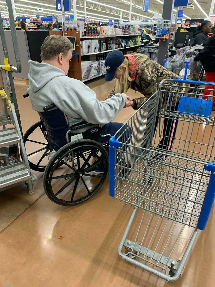 Señora rezando por este hombre para que pueda volver a caminar