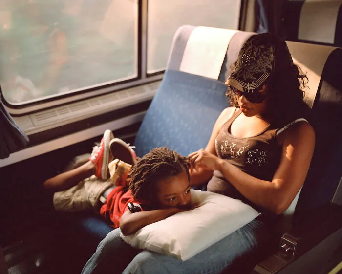 Madre arreglando el pelo de su hijo en el tren