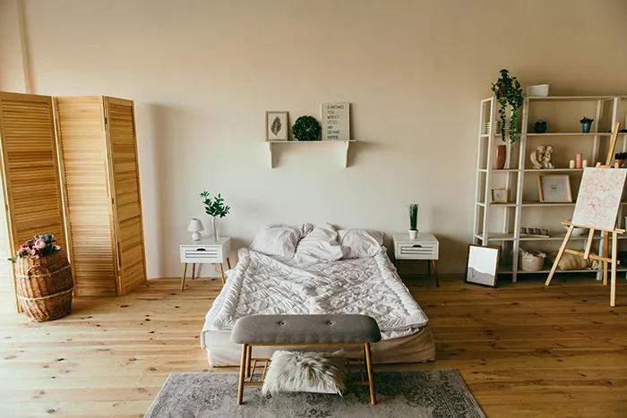 Bedroom area with cool and inspiring wall decor ideas featuring minimalistic shelves, plants, and art in a cozy space.