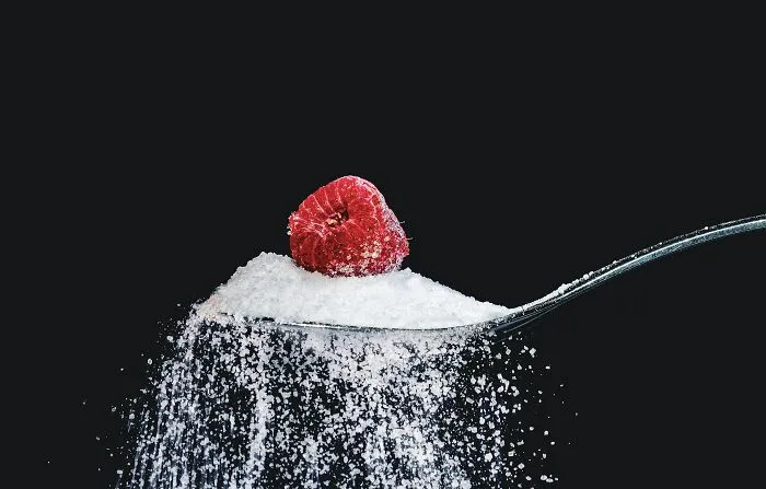 Spoon with sugar and a raspberry, sparking shower thoughts on contrasts and combinations.