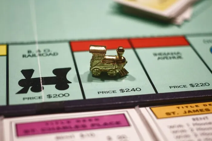 Monopoly board with a train token on the B&O Railroad spot, linked to shower thoughts questions about life.