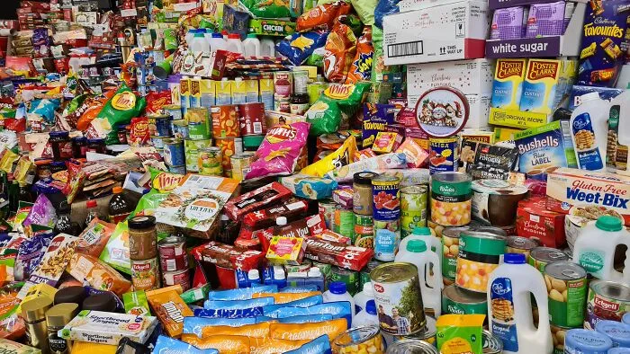 A vast assortment of groceries and snacks stacked in a colorful, chaotic arrangement, sparking shower thoughts questions.