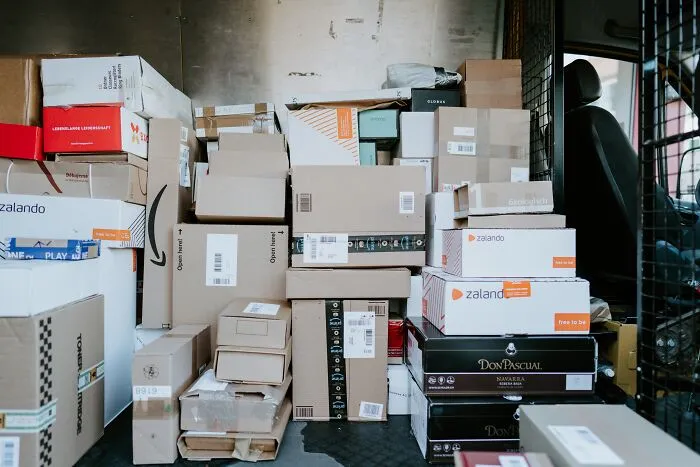 Boxes stacked inside a delivery truck, showcasing a variety of packaging and brands.