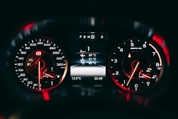 Close-up of car dashboard with speedometer and tachometer, evoking shower thoughts questions.