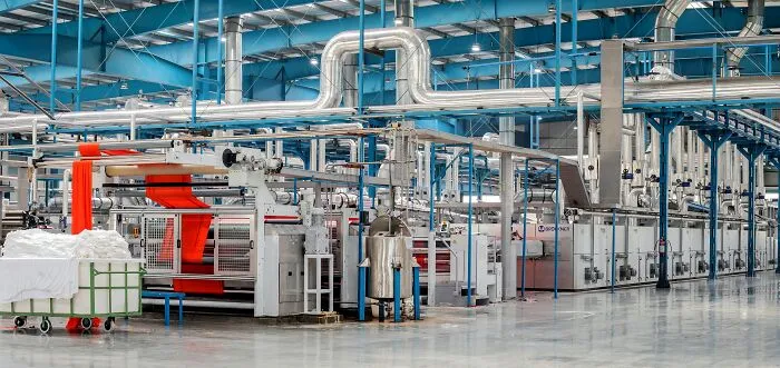 Modern industrial facility with large machinery and metal pipes, illustrating innovation in a manufacturing setting.