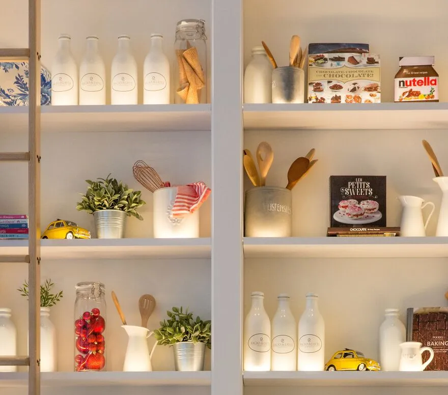 Shelves with kitchen appliances and decor arranged in modern and stylish kitchen cabinets for renovation inspiration