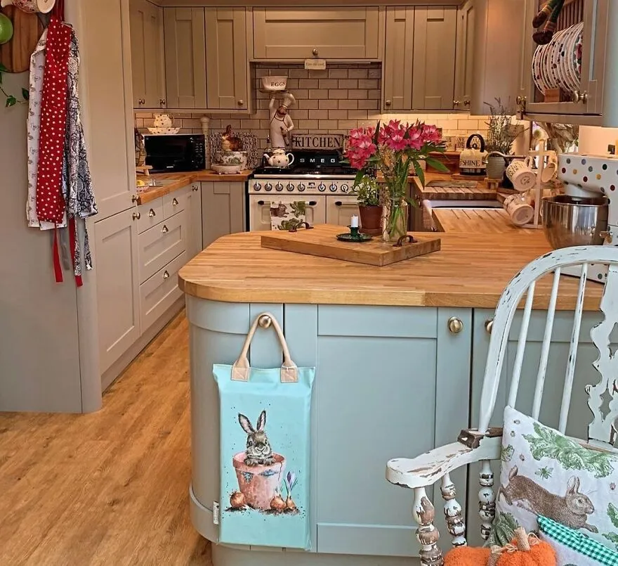 Cottage kitchen with modern and stylish kitchen cabinets in grey and turquoise, featuring wooden countertops and decor.