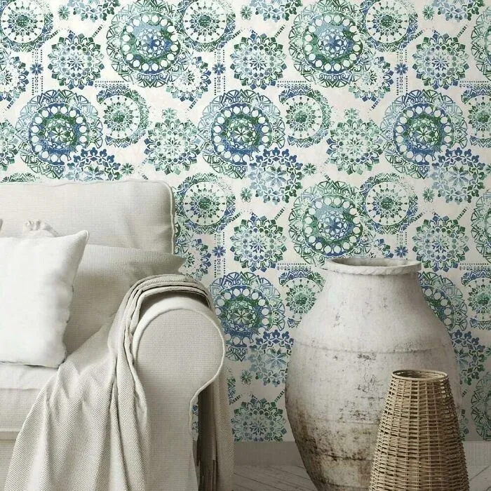 Room with colorful boho style wallpaper and white sofa with empty bowls near