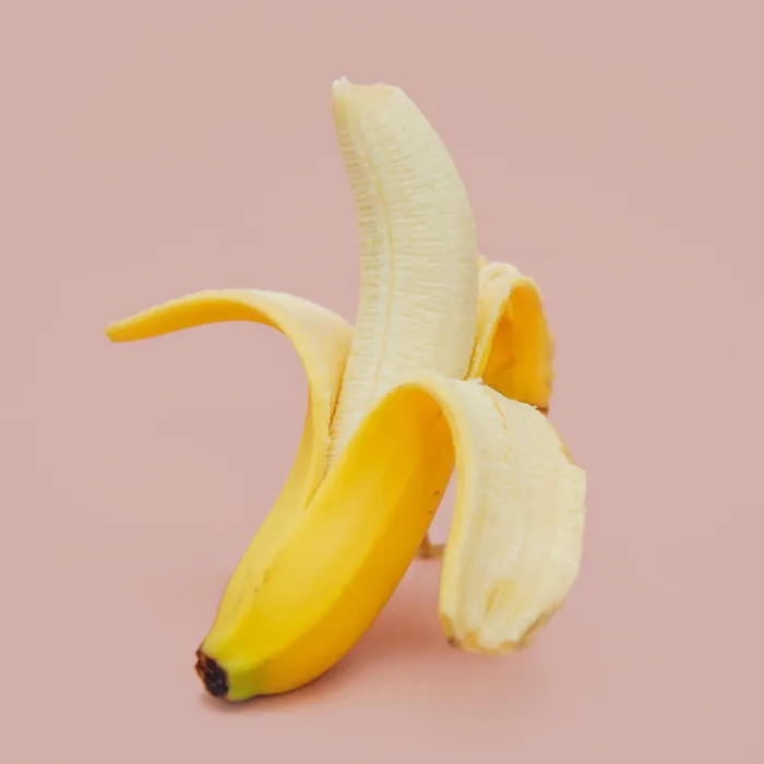 Peeled banana on a pink background representing one of the weirdest Guinness World Records related to unusual objects.