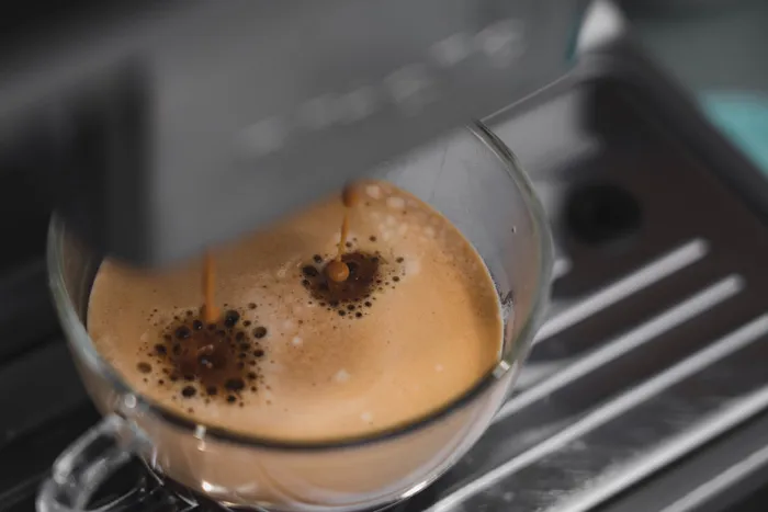 Close-up of espresso being brewed in a coffee machine, a unique moment capturing unusual Guinness World Records.
