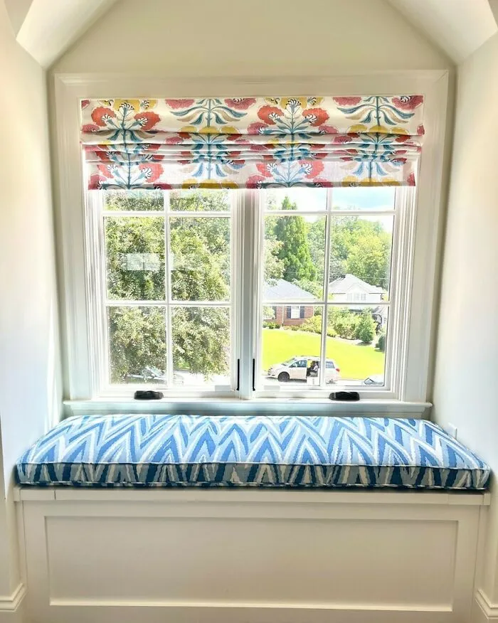 Colorful window seat cushion with patterned fabric in a bright window nook creating a cozy space in the home.