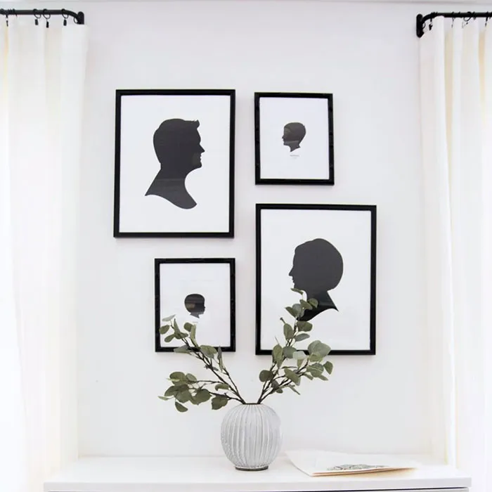 Framed silhouette pictures arranged on a white wall with minimalist decor for easy and creative wall art ideas.
