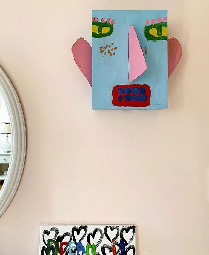 Painted show box wall art featuring a colorful abstract face, showcasing creative wall art ideas for a stylish space.