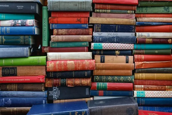 Pile of hardcover books stacked tightly, perfect for those seeking hard riddles to challenge their wits and knowledge.